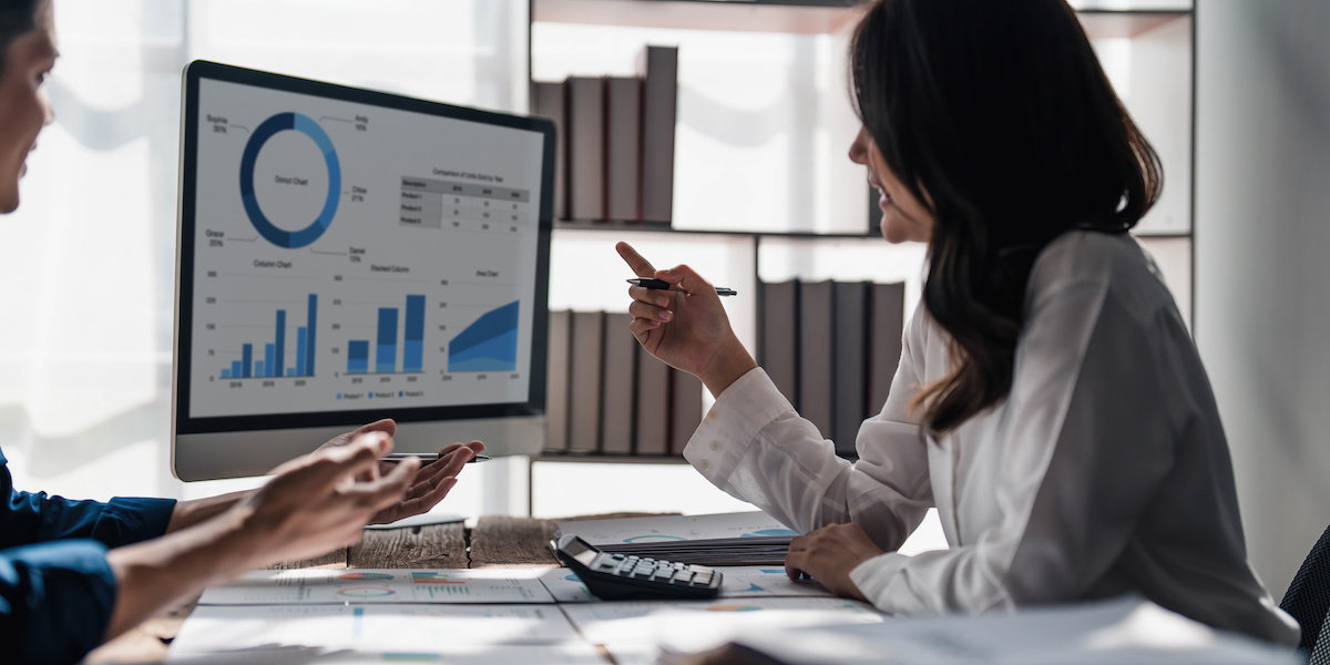 Two coworkers reviewing financial data in a corporate setting. 