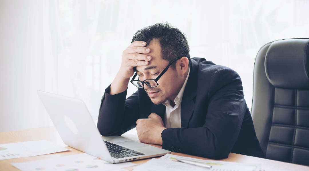 Man tired at desk in suit