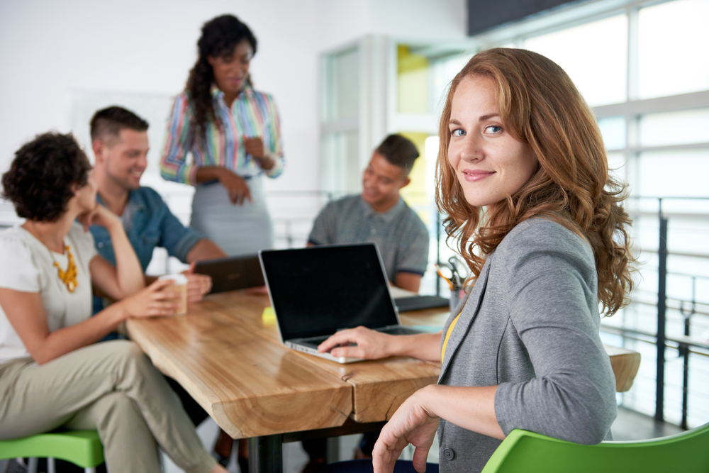 Smiling person at a table with a team.