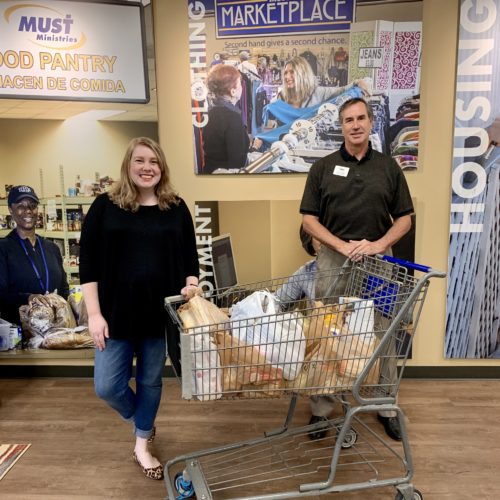 man and woman sitting infront of shopping cart