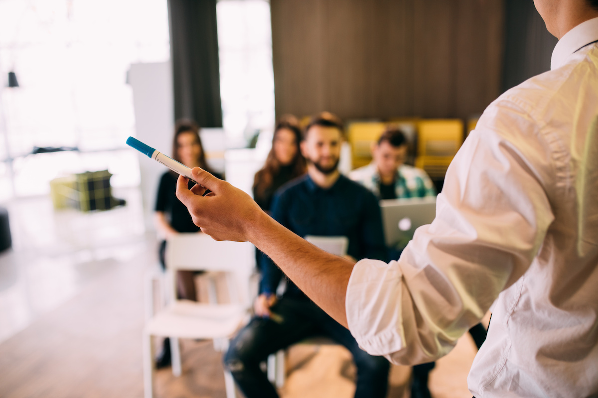 Instructor leading a sales training class in a corporate setting